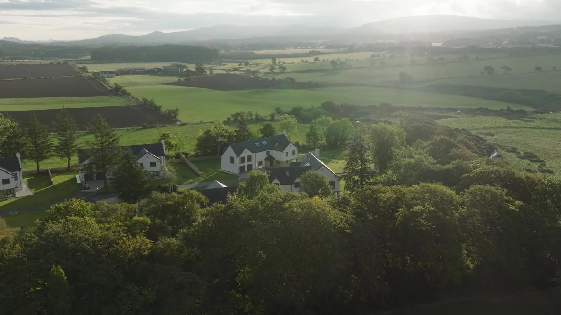 Inveroe Steadings surrounded by trees and open countryside in the morning light