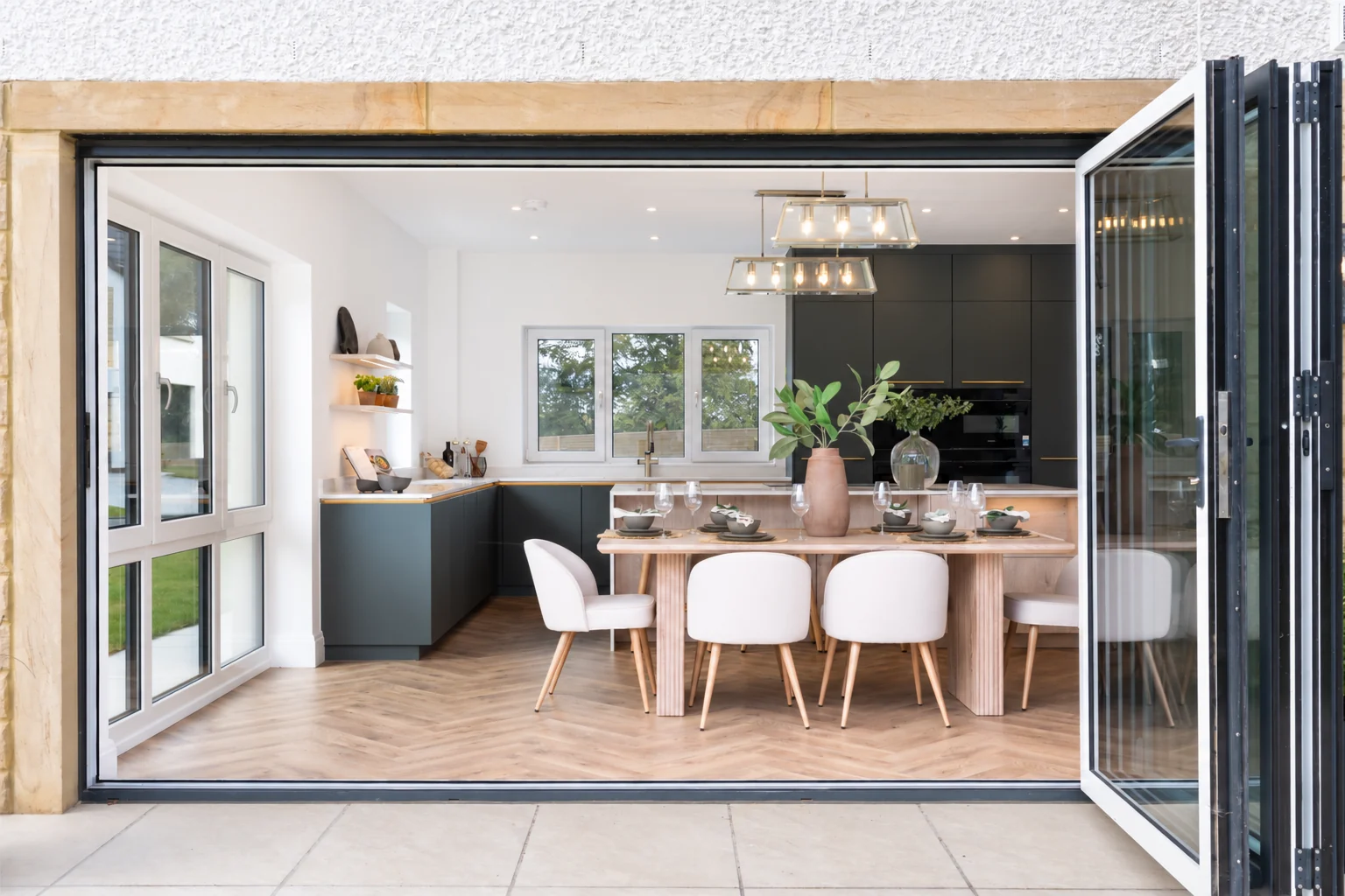 Wide folding doors connect the kitchen and dining room to the terrace
